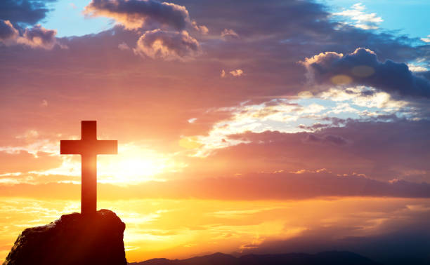 Religious cross on the hill at sunset stock photo