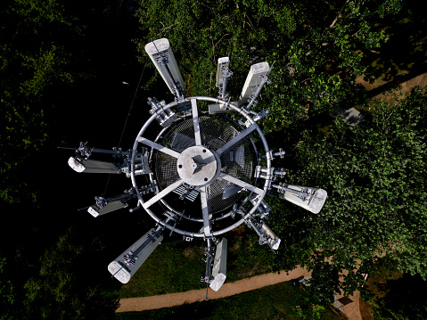 transmission of various drum shapes on a telecommunications tower. colors white and khaki green cones. transfer of phone signal and 5g, 4g internet. multiple TV antenna amplifier, transmitter