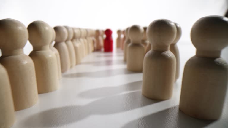 Red wooden figurine of human in crowd of figurines