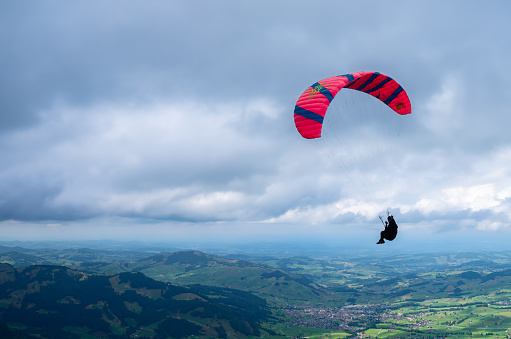 Altstatten, Switzerland - July 4, 2023: A paraglider circles the top of the Hoher Kasten mountain
