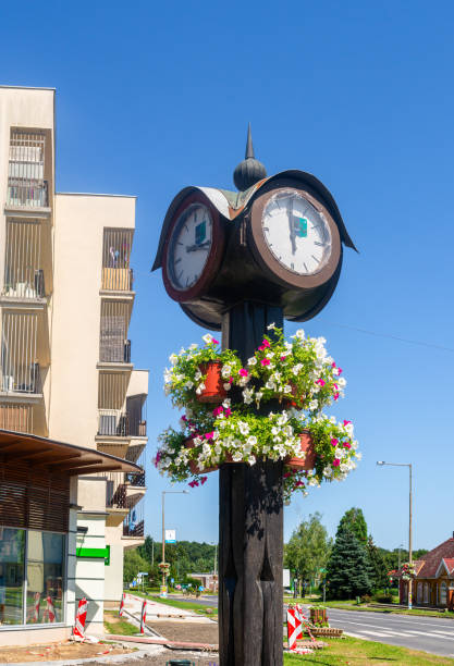 Lenti, Hungary - July 15, 2023: Old street watch and flower decoration in the town of Lenti