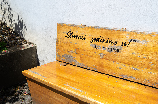 Ljutomer, Slovenia - July 14, 2023: A wooden bench with inscription: Slovenians, let us unite!