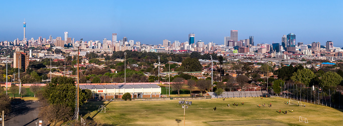 Johannesburg Panoramic seen from the West rand with the sports ground of WITS university in the foreground. Johannesburg is also known as Jozi, Jo'burg or eGoli and is the largest city in Southern Africa.