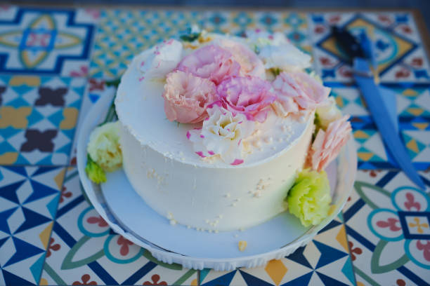istock Classic white cake decorated with pink and white fresh flowers. 1667124497