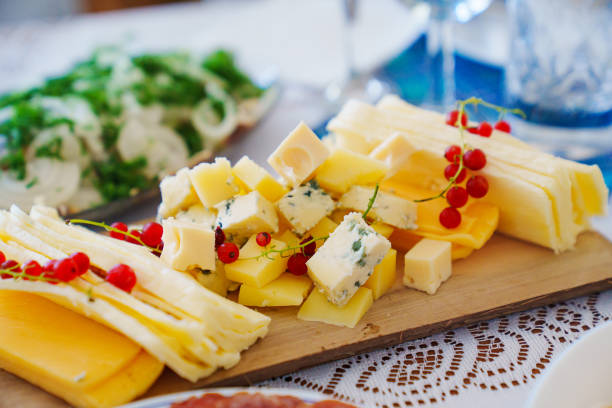 istock Wooden tray with cheese platter and currants on the served table. 1667144974