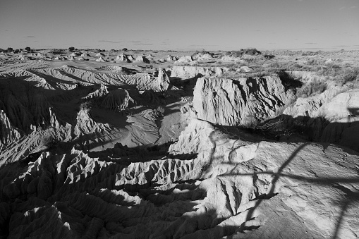 A black and white image of a mountainous landscape featuring snow-capped peaks and lush vegetation