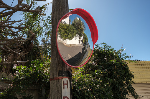 Curved traffic mirror on a wooden utility pole.