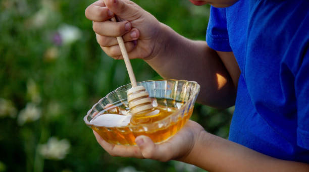 istock boy eats honey in nature, homemade honey. Selective focus 1667183961