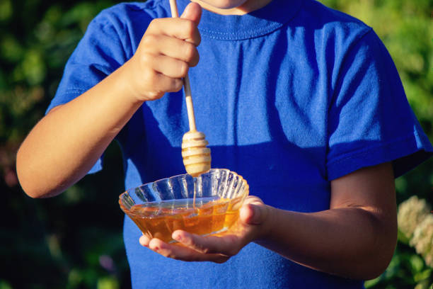 istock boy eats honey in nature, homemade honey. Selective focus 1667183962