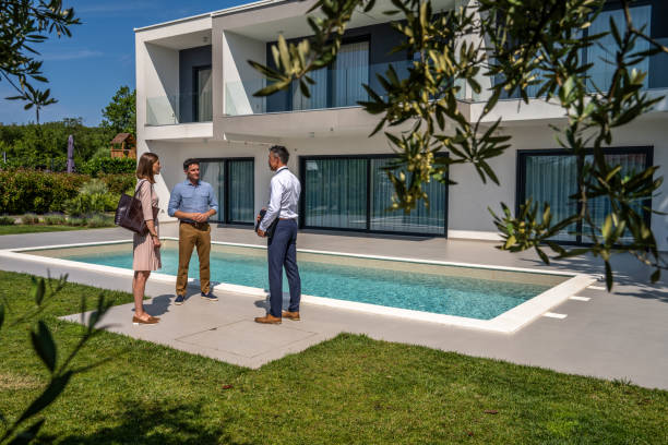 istock Male real estate agent talking with couple 1667208188