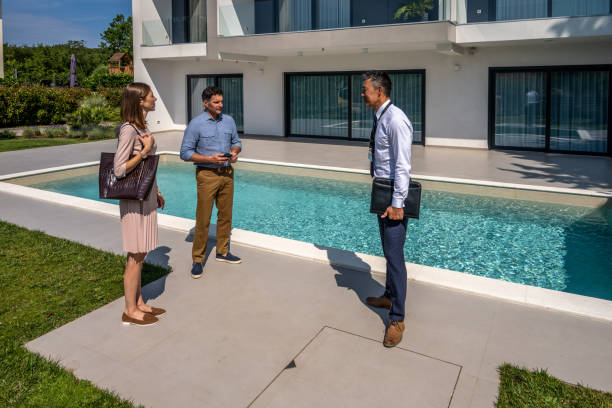 istock Male real estate agent talking with couple 1667208193
