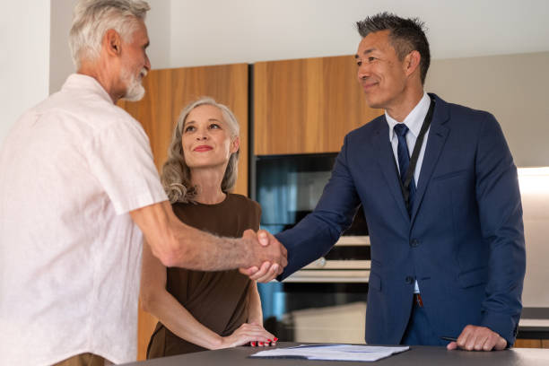 istock Male real estate agent shaking hands with couple 1667208204