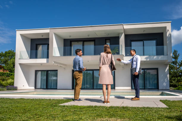 istock Male real estate agent talking with couple 1667208225