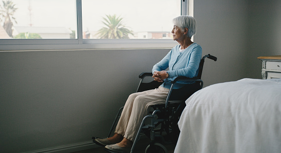 Wheelchair, senior and thinking at window in retirement with memory, insurance or space. Sick elderly person patient with a disability in care home with Alzheimer, dementia and depression or lonely