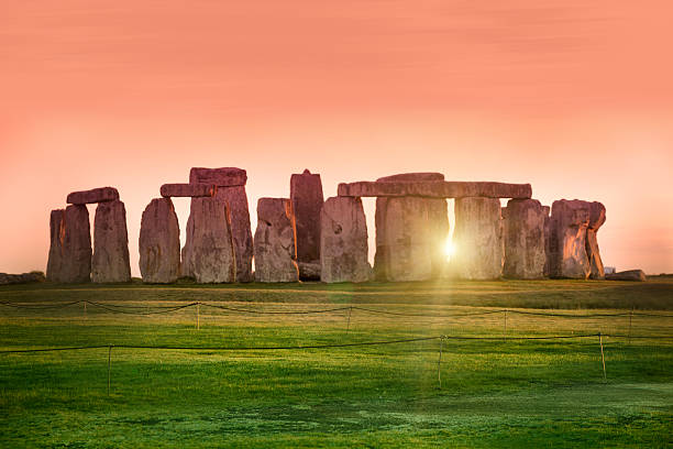 Sunset at the Stonehenge, United Kingdom The prehistoric monument of Stonehenge in England.  Focus is on the grass. summer solstice stock pictures, royalty-free photos & images