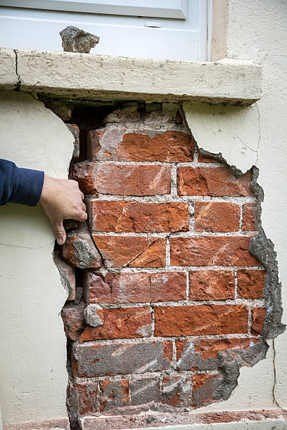 Structural problem: crack in wall Surveyor examines a large crack in a building wall stability stock pictures, royalty-free photos & images