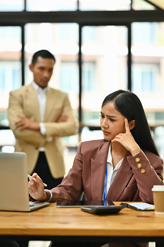 Overwhelmed female employee having problems, feeling tired at corporate meeting. Stress at work concept.