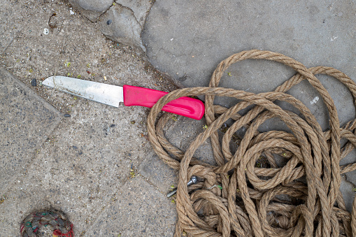 Close-up shot of knot tied to boat on pier in harbor