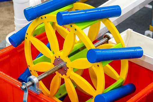 An antique wooden spinning wheel with yarn and bobbins isolated on a white background