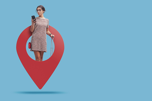 Young traveling woman in a GPS pin using her smartphone and booking services, travel and tourism concept