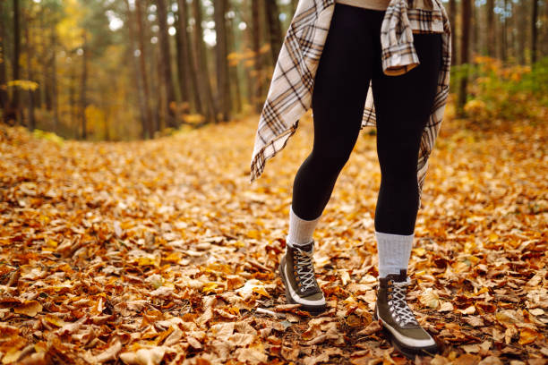 istock Woman's legs in boots in autumn foliage. Leaf fall. 1667301828