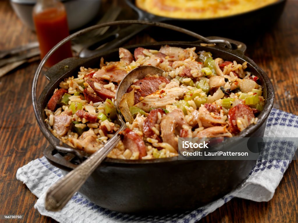 Jambalaya Cajun Style Chicken and Sausage Jambalaya in a Cast Iron Pot with Hot sauce and corn bread- Photographed on Hasselblad H3D2-39mb Camera Jambalaya Stock Photo