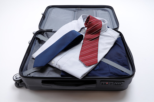 Businessman preparing for business trip. carry case and shirt