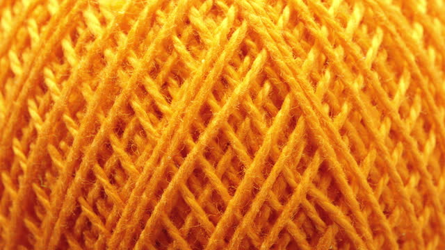 Texture of threads in a spool of yellow color.