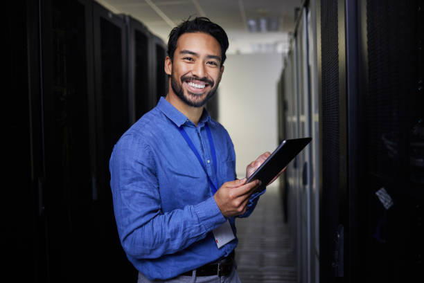 istock Tablet, man and portrait in server room of engineer programming at night. Information technology, face and happy Asian technician in data center, networking and coding software of system admin expert 1667364784