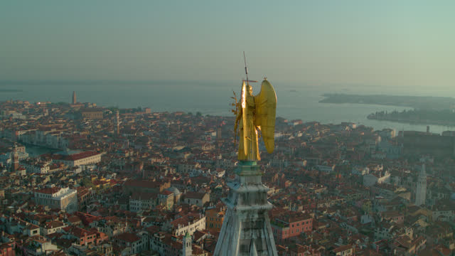 Aerial view of St. Mark's bell tower and spire in Venice, Italy at sunset. 4K