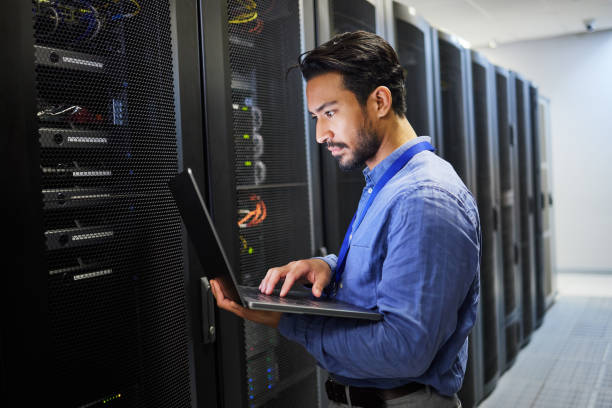 Programming, data center and a man with a laptop for maintenance, cyber security and internet check. Coding, email and an Asian programmer typing on a computer for network or server analytics programación, centro de datos y un hombre con una computadora portátil para mantenimiento, seguridad cibernética y verificación de internet. codificación, correo electrónico y un programador asiático escribiendo en una computadora para análisis de