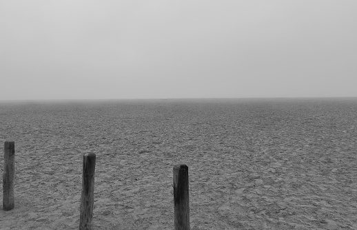 Wooden gutters on a pebbly beach on the Eastbourne coast on a foggy day