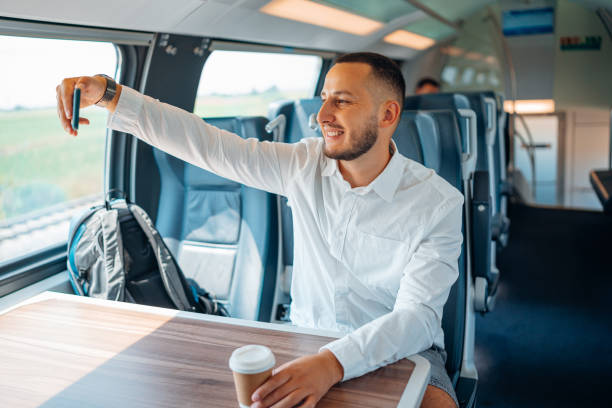 istock Young Caucasian man cheerfully taking a selfie, while sitting in a train 1667449260