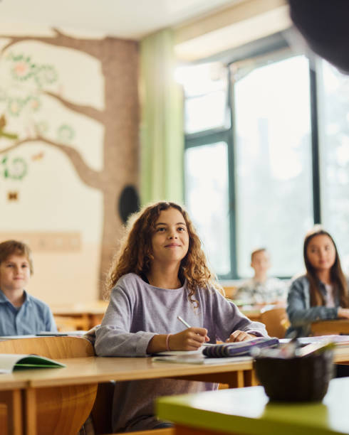 улыбается ученик начальных классов на уроке в школе. - elementary student classroom education elementary school building стоковые фото и изображения