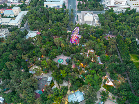 Aerial view of Panfilov Park in Bishkek city with Ferris wheel surrounded with green trees