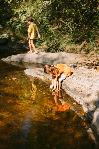 istock Children playing and explore the nature by the river 1667470125