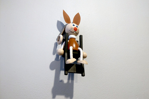 A funny hare toy hangs on the wall