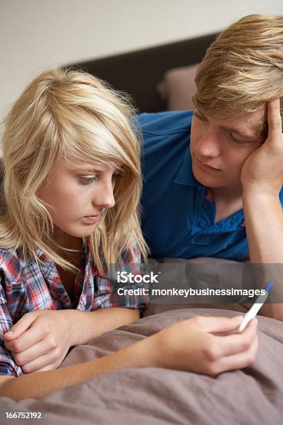 Teenagers Lying On Bed Looking At Pregnancy Testing Kit Stock Photo - Download Image Now