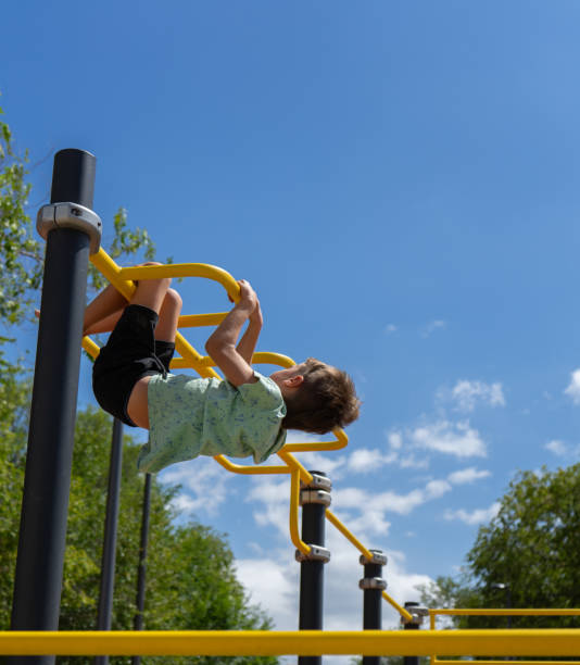istock Child climbing over the top of a playground structure 1667545024