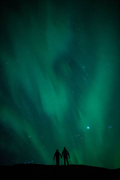istock Northern lights (Aurora borealis) and silhouetted couple honeymoon 166754645