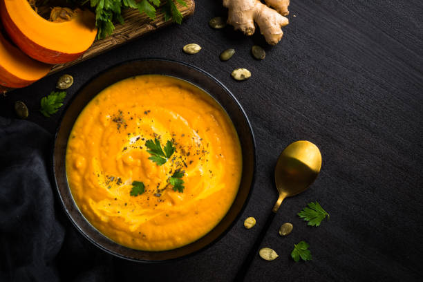 istock Pumpkin soup puree with cream at black table. 1667557461