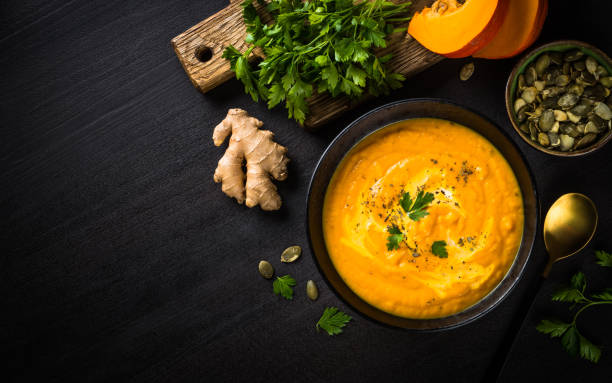 istock Pumpkin soup puree with cream at black table. 1667557465