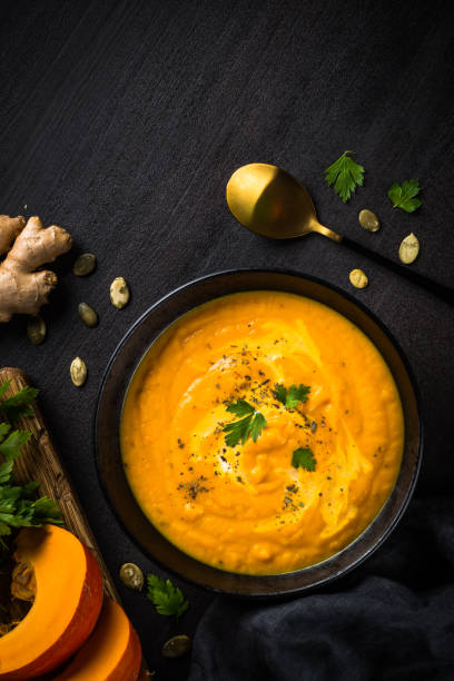 istock Pumpkin soup puree with cream at black table. 1667557470