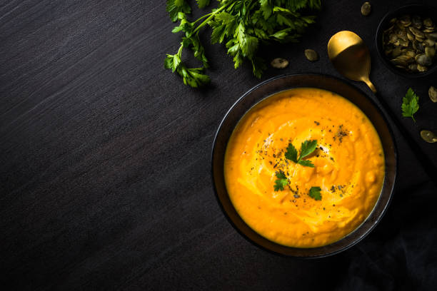 istock Pumpkin soup puree with cream at black table. 1667557478