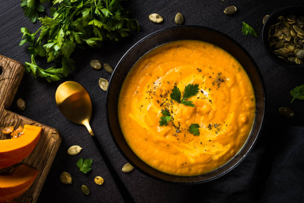 istock Pumpkin soup puree with cream at black table. 1667557492
