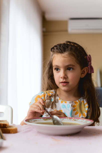 istock Child looking at laptop and watching videos on internet while eating on a table in the kitchen 1667564809