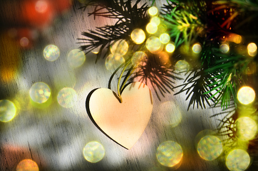 Christmas night, glittering golden lights. Christmas decoration in heart shape. Concept of New Year celebration. Copy space