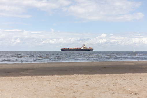 Large cargo ship sailing on the North sea in Germany. View from the beach.