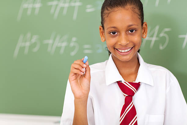 istock primary schoolgirl holding chalk 166759903