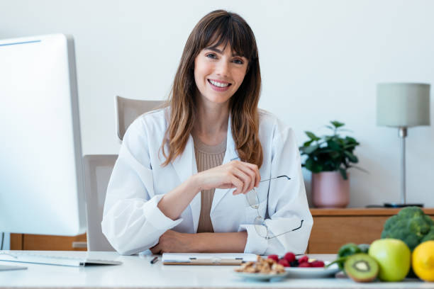 istock Beautiful smart nutritionist woman working with computer while looking at camera in the nutritionist consultation 1667608790